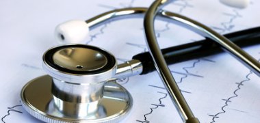 A stethoscope on the top of the EKG chart A stethoscope on the top of the EKG chart