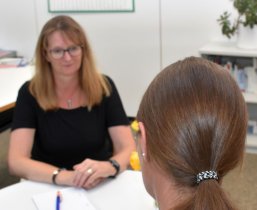 Eine Klientin sitzt einer Beraterin gegenüber