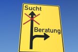 Ein Straßenschild auf dem der Weg in die Sucht durchgestrichen und nur der Weg zur Beratung frei ist.