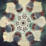 Eine Gruppe Chirugen beugt sich über den Patienten