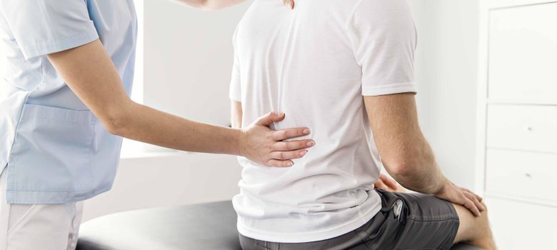 53_1_Heilpraktiker_Physiotherapie Ein Mann drückt auf den Rücken eines Patienten