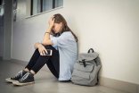 53_3_Schulprobleme Ein Mädchen hält seitzend den Kopf in den Händen