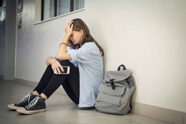 53_3_Schulprobleme Ein Mädchen hält seitzend den Kopf in den Händen