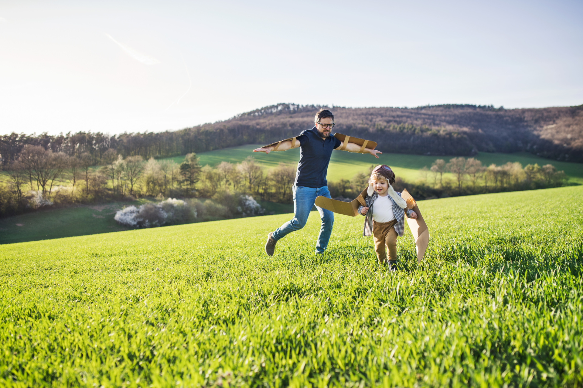 Happy toddler boy playing outside with father in spring nature. Vater und Kind
