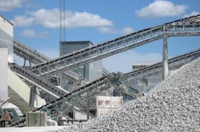 Kieswerk - Zementwerk Hohe Kieshaufen im Vordergrund, im Hintergrund verschiedene Beförderungsbänder