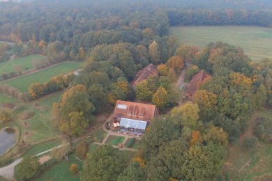 Luftbild Gut Nordholz Luftbildaufnahme der Gebäude vom Gut Nordholz, umgeben von vielen großen Bäumen und teils Wiesen. Links unten im Bild ist ein Teich zu erkennen