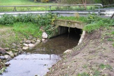 Wasserdurchlauf unter einer Straße Kanal mit Wasser, der unter einer Straße durchführt