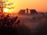 Türme einer Kläranlage im Hintergrund bei Sonnenaufgang im Nebel 