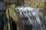Wassermühle Wasserrad einer Wassermühle, welches aktiv ist und durch das Wasser läuft.