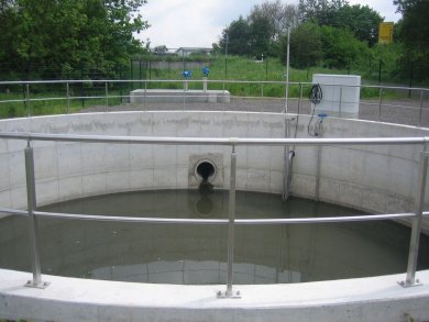 Kreisförmiges, betoniertes Becken, welches zum teil mit Wasser befüllt ist.