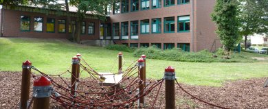 Schule Eickhorst Fotografie zeigt einen Gebäudeteil der Schule Eickhorst mit Kletterseilen im Vordergrund